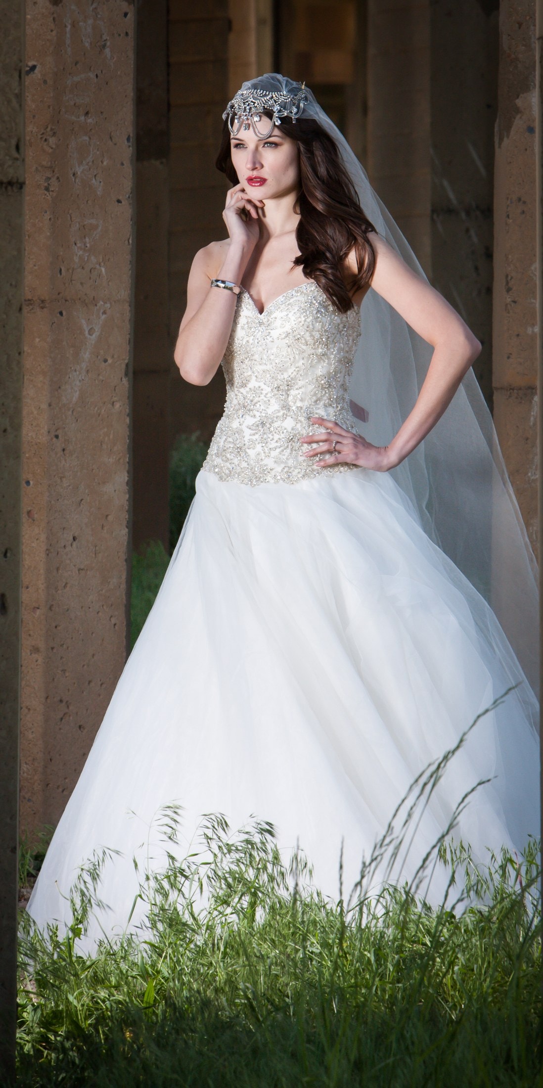 Bride in a full gown against a stone wall