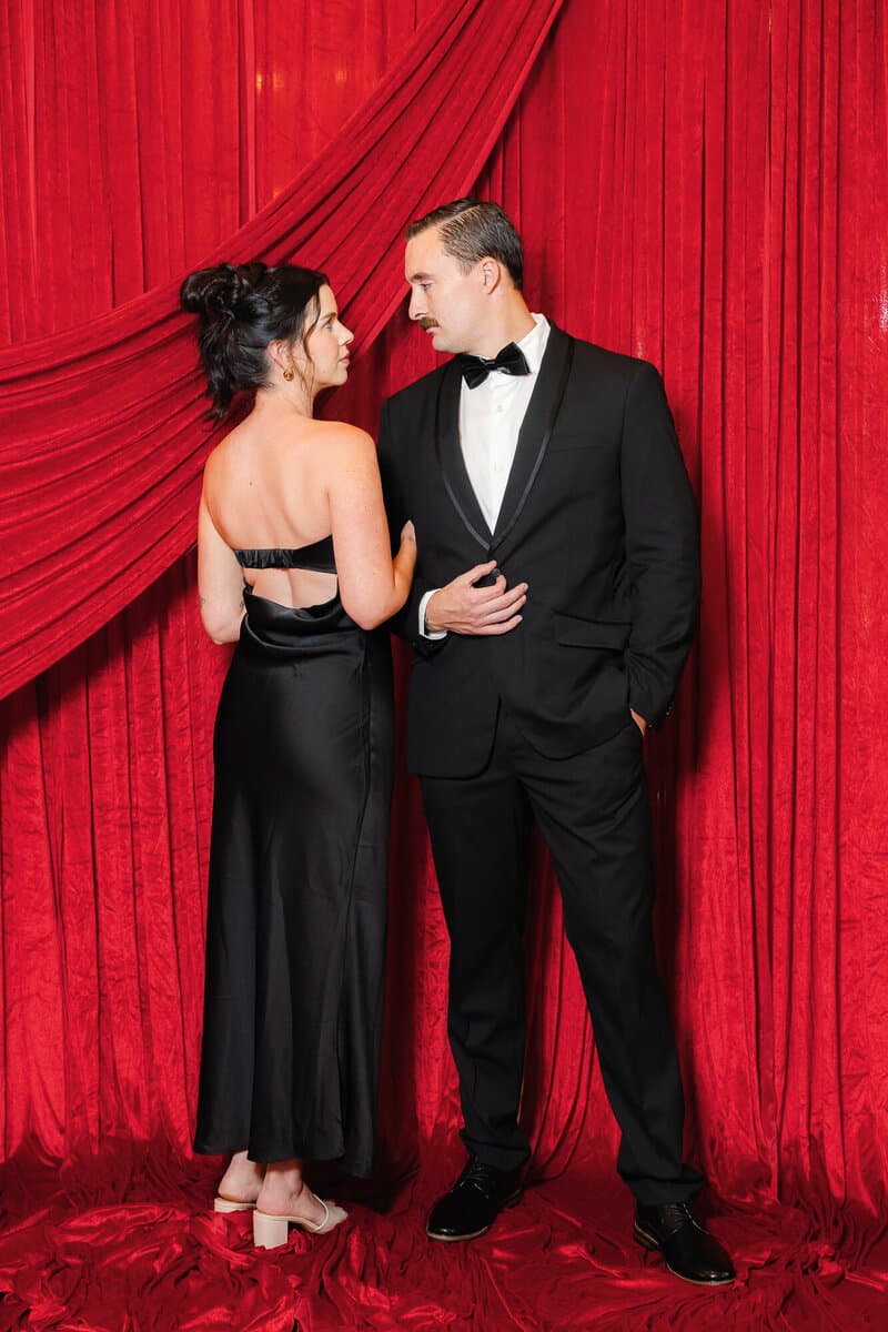 Couple in black tie on the red velvet set